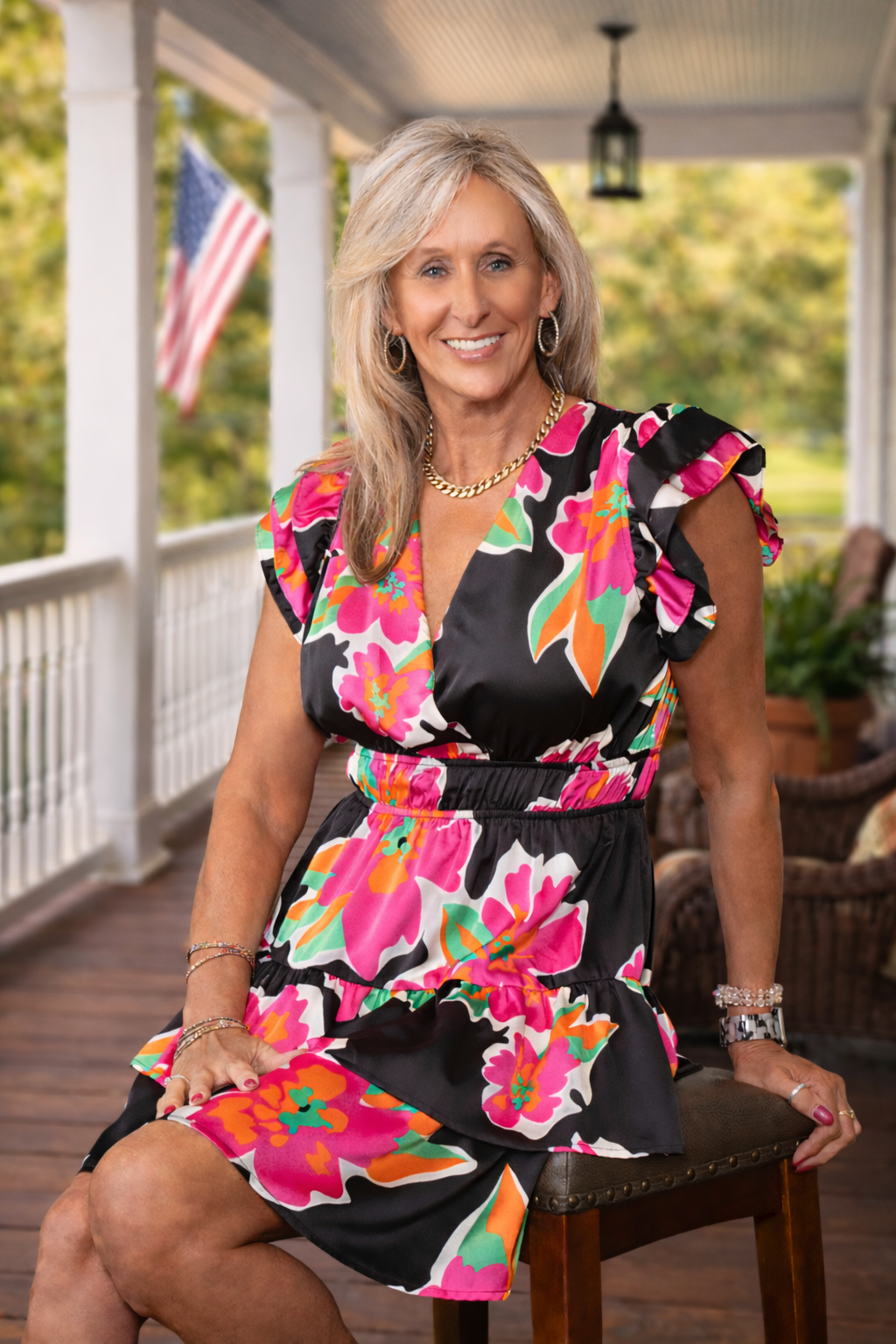 Smiling woman on porch in vibrant dress (2)